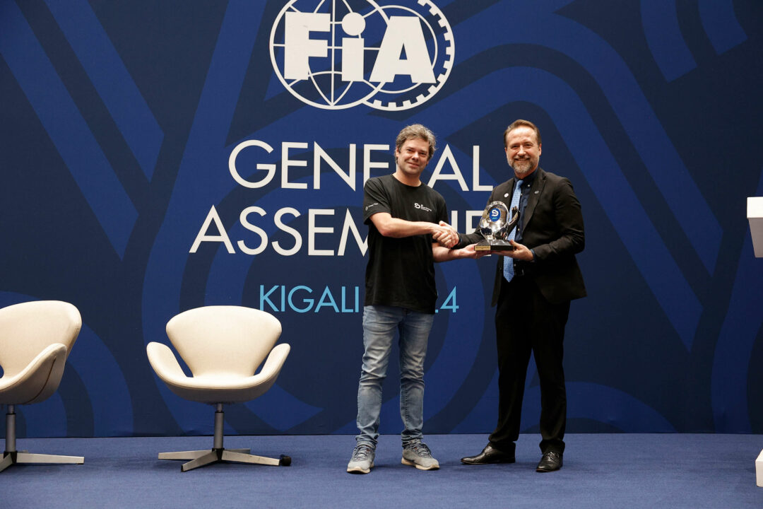 FIA Smart Driving Challenge 2024 winner gets his prize from an FIA employee on a stage in Kigali, Rwanda