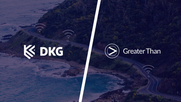 DKG and Greater Than logos on a background showing cars driving on a road by the ocean
