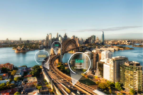 Image of a city from above where cars are driving on a bridge that is going over the water. Three cars has Crash Probability markers above them saying Low and Medium risk.