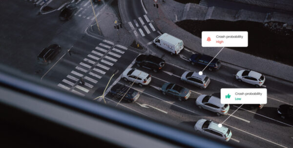 Cars waiting at a crossing with crash probability risk banner above two cars.