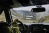 Man driving a car from the inside with nature landscape outside, a card shows driver feedback for safe driving