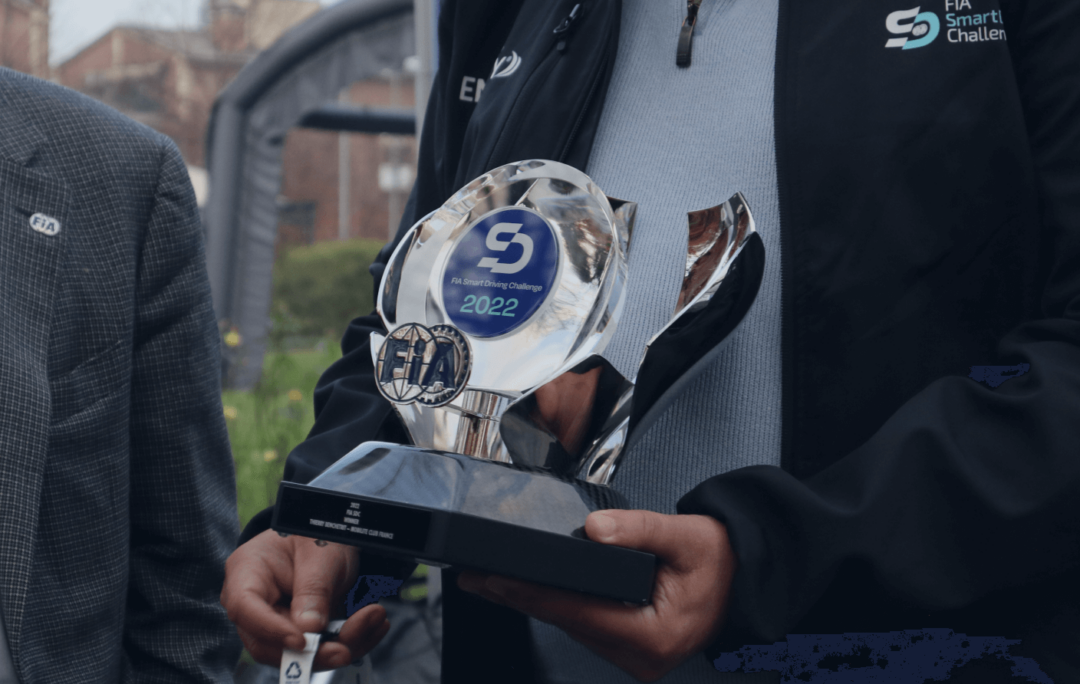 Man holding the FIA Smart Driving Challenge 2022 trophy in his hand.