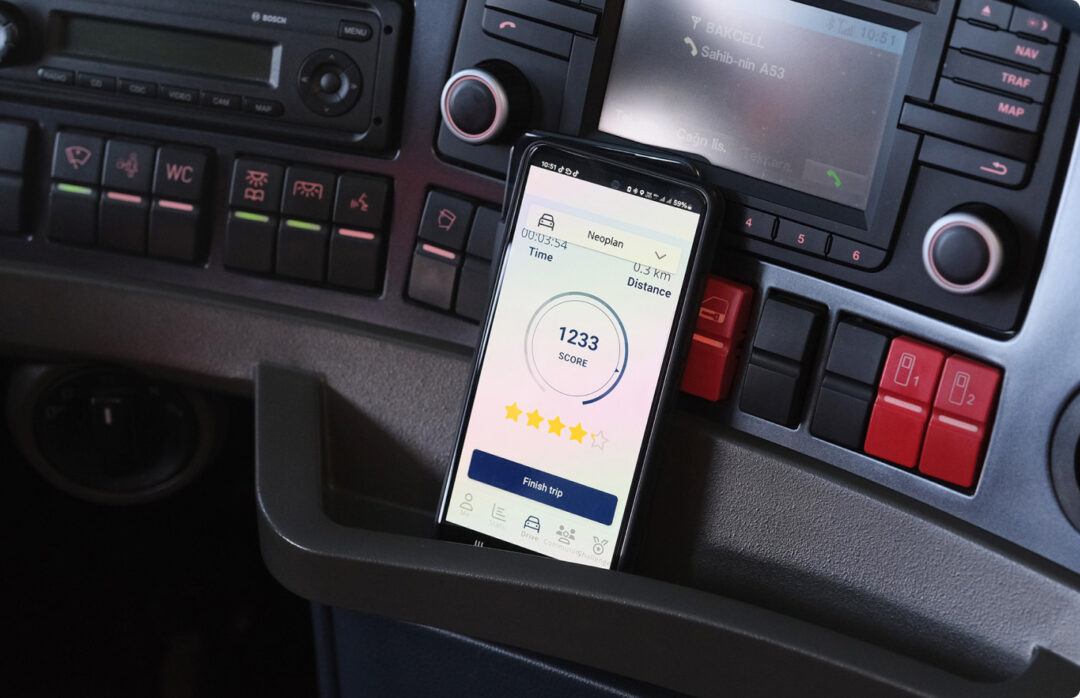 FIAスマート・ドライビング・チャレンジのアプリが入ったバスのインフォテインメント・システムに横付けされたスマホ