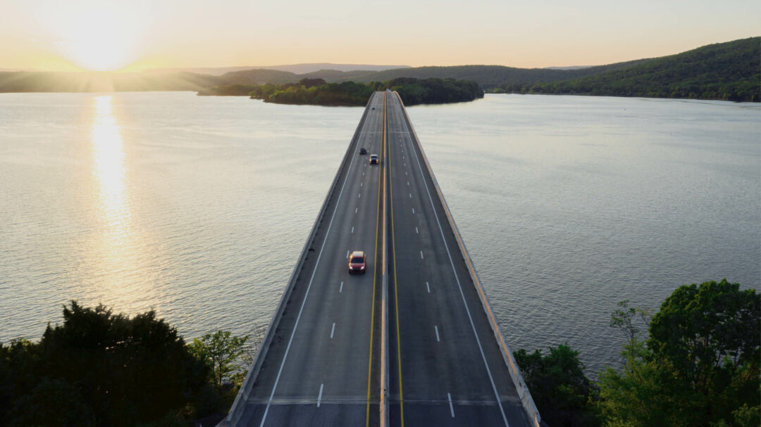 Cars driving on a bridge that goes between islands over water