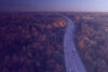 Highway with cars from above in forest during fall