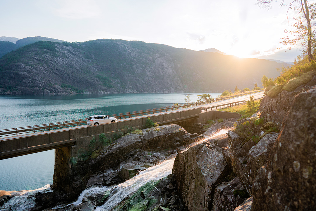 A car driving on a bridge into the horizon