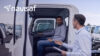 A man sitting in the driver’s seat of a truck receiving coaching from another man standing outside, both engaged in discussion, illustrating driver training and performance feedback. The Navisaf logo is in the upper left corner.