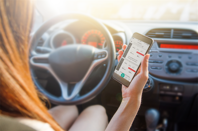Kvinna som kör bil och tittar på Moderna Smart Flex app