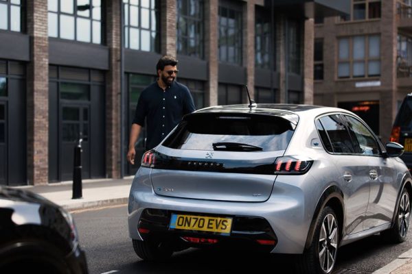 Man walking by a silver car