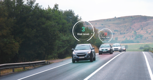Cars driving on a road with Risk level markers showing above them.