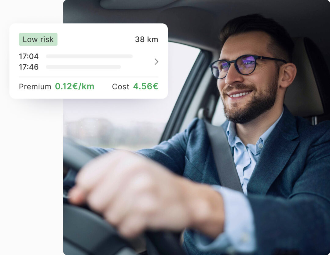 Smiling man in a car, wearing glasses and a seatbelt, with an overlay showing a driving summary: labeled 'Low risk' for a 38 km trip, including start and end times, premium rate of 0.12€/km, and total cost of 4.56€.