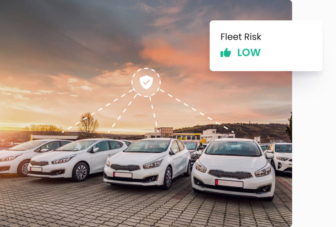 Low fleet risk rating displayed above connected fleet of white cars in parking lot – fleet safety insights visualized