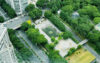From above showing streets with cars, trees and a tennis court