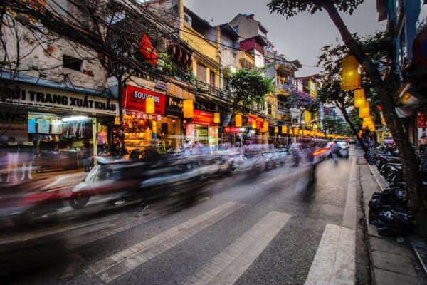 Cars driving fast on a street in the evening