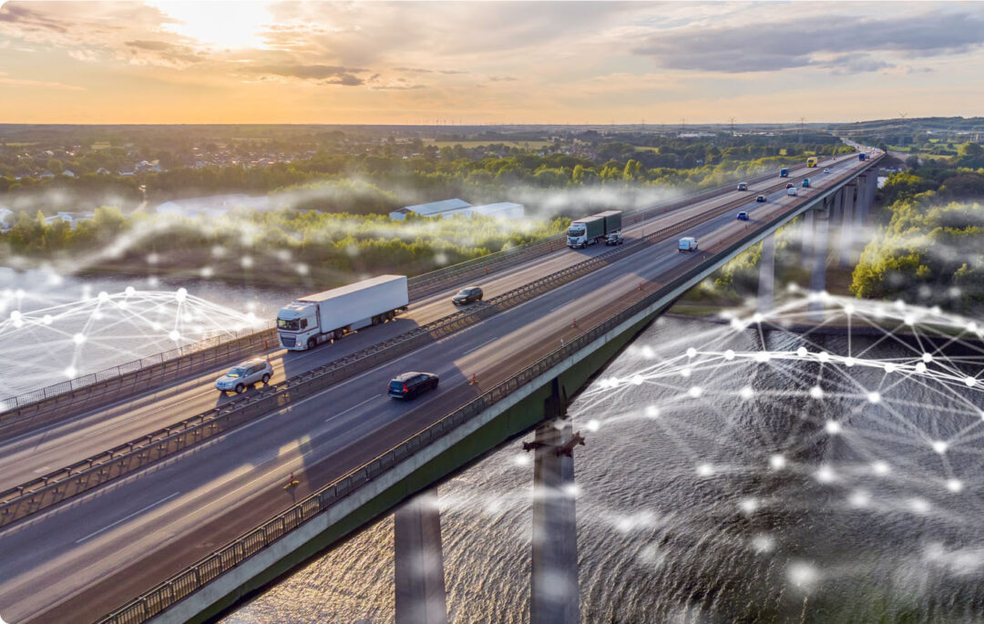 Bridge with cars going over a river. Green landscape on the other side of the river. Graphic to show AI on top of the image.